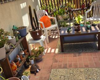 Outdoor furniture, lots of potted plants and cool pottery pots
