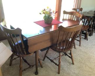 Drop leaf cherry table enhanced with four Hitchcock chairs