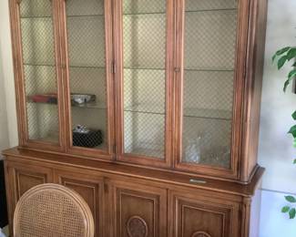 The matching China cabinet has glass shelves and lights.