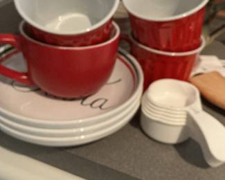 Red Ceramic Coffee Mugs with Pink Rimmed Saucers and Plastic Measuring Cups
