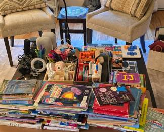 Soft white chairs, wooden table, books and office supplies