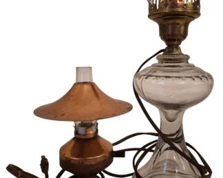 4048 - Two Vintage Electrified Oil Lamp Style Lamps (Description): Two electric lamps in vintage oil lamp style.  One features a copper-toned metal body with  a matching conical shade and wooden base. The  other is a clear pressed glass lamp with a  brass-finished crown burner top, converted for electric use. Both lamps retain their  original cords. Used as is electric/electronic/mechanical  item. No guarantee all components, untested.