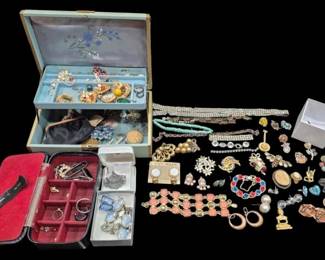 2816 - Costume Jewelry Lot w/ Jewelry Box (Description): An assorted collection of costume jewelry  including rhinestone necklaces, brooches,  earrings, bracelets, and various pins. The  lot features pieces in gold and silver tones  with colorful stones and crystals, including turquoise beaded necklaces, pearl earrings,  floral brooches, and statement pieces. Also  includes a vintage jewelry box with  embroidered floral design on blue satin  interior, as well as a travel jewelry case