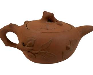 288 - Yixing Zisha Pottery Handmade Teapot (Description): Yixing Zisha pottery handmade teapot  featuring traditional terracotta-colored clay  with applied relief decoration of flowering  branches and buds on the body and lid. The  teapot has a naturalistic twig-form handle and spout with a sculptural floral finial on  the lid. Measures 3.75" x 7".