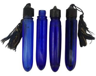 877 - 4 Vintage Cobalt Glass Vials (Description): A collection of four vintage cobalt glass  vials. These deep blue glass vessels feature  elongated forms with various cap styles, some  adorned with decorative tassels.