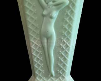 407 - Nude Jadeite Glass Vase 8.5" (Description): Jadeite glass vase featuring a nude female  figure in relief. The vase displays a lattice  pattern design with vertical ribbing along  the sides and rests on a decorative footed  base. Measures 8.5 inches tall. Glows under black light.