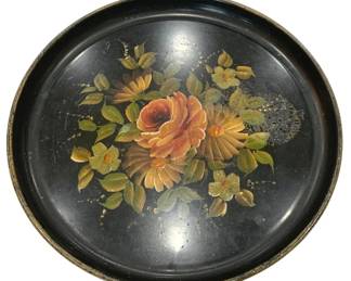 949 - Hand Painted Black Tole Tray w/ Florals 14" (Description): Vintage hand painted black tole tray  featuring a central floral bouquet design.  The decorative painting depicts roses,  daisies, and small blossoms in warm orange,  peach, and yellow tones surrounded by green foliage against the black japanned  background. The round tray has a raised rim  and shows characteristic wear consistent with  age and use.