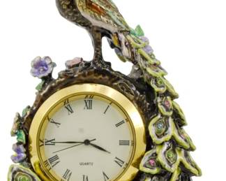 164 - Dept 56 Bejeweled Peacock Clock 4.5" (Description): Dept 56 bejeweled peacock clock featuring a  decorative peacock figure with colorful  rhinestone accents perched atop a quartz  clock face with Roman numerals. The elaborate  tail feathers cascade down around the clock, embellished with multicolored stone. Used as is electric/electronic/mechanical  item. No guarantee all components, untested.