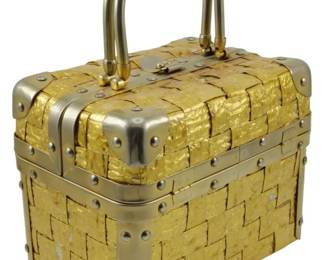 1777 - Delill Trunk Handbag Gold Tone Foil 6"x8"x5" (Description): Delill trunk-style handbag featuring a gold  tone foil woven exterior with silver tone  metal hardware, corner brackets, and riveted  accents. The bag has a hinged lid with clasp  closure and a curved metal carrying handle. Measures 6 inches wide by 8 inches long by 5  inches tall.