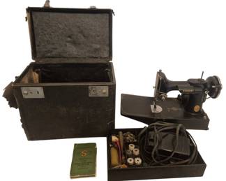 2792 - Singer Featherweight Sewing Machine w/ Case (Description): Vintage Singer Featherweight portable sewing  machine in black with gold decal accents  serial #AG706578. Comes with original black  carrying case, foot pedal with power cord,  instruction manual, and accessory tray containing bobbins and various sewing  notions. A classic and highly collectible  compact sewing machine known for its  portability and reliability. Used as is electric/electronic/mechanical
