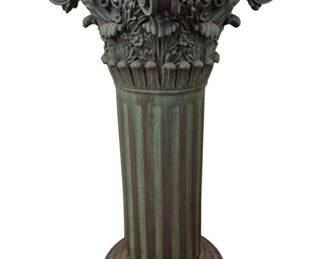 1292 - Corinthian Column Style Plant Stand 29"x14" (Description): Corinthian column style plant stand featuring  an ornate acanthus leaf capital with  scrolled volutes at the corners. The fluted  column shaft rises from a stepped circular  base. The piece has a verdigris green patina finish that gives it a classical bronze-like  appearance. Measures 29 inches tall by 14  inches by 14 inches.