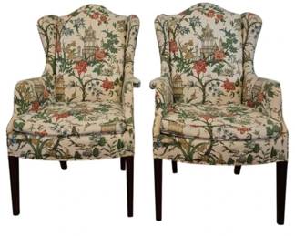 307 - Pr Kindel Chinoiserie Upholstered Chairs (Description): Pair of wingback chairs upholstered in a  vibrant chinoiserie fabric featuring pagodas,  flowering trees, birds, and botanical motifs  on a cream ground. The chairs rest on dark  wood straight legs in a traditional style. Measures 43 inches high by 27 in