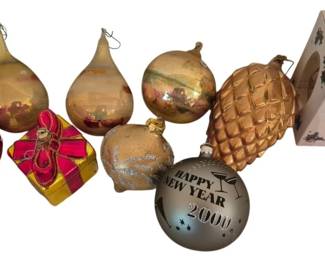 4058 - Group of West German Glass Ornaments (Description): A collection of vintage glass Christmas  ornaments including West German examples. The  group features various shapes and styles  including teardrop forms with hand-painted  floral designs, a pink polka dot ornament, a red and gold gift box ornament, a gold  pinecone, a glittered acorn, and a silver  Happy New Year 2000 commemorative ball. Also  included is a Santa on Silk glass collectible  ornament in its original box. The ornaments