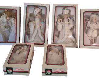 4063 - Group of 6 Vtg Kurt Adler Angel Figurines (Description): Group of six vintage Kurt Adler angel  figurines, each presented in original Santa's  World packaging. The angels feature elegant  white and cream-colored costumes with  delicate lace, feathered wings, and refined detailing. Each figure displays unique  styling and poses, making them ideal for  holiday display or collecting.