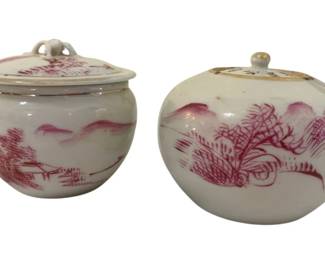 327 - 2 Chinese Porcelain Jars w/ Lids 2.5"x3" (Description): Two Chinese porcelain jars with lids,  featuring hand-painted puce or pink  monochrome landscape and botanical scenes.  Both jars have a white ground with delicate  brushwork depicting traditional Chinese scenery including mountains, trees, and  foliage. Each jar is fitted with a matching  lid with small finial. Measures 2.5" x 3".