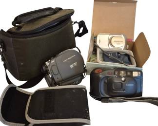 1425 - Assorted Cameras & Camcorder w/ Cases Lot (Description): Includes a Sony Handycam DVD camcorder with  carrying case, a Canon 35mm point-and-shoot  camera with built-in flash, an Olympus  digital camera, and additional camera  accessories. Various carrying cases and bags included. Used as is electric/electronic/mechanical  item. No guarantee all components, untested.