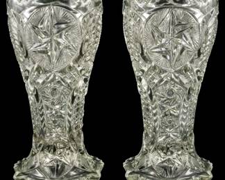 146 - Pair Pressed Glass Vases 9" (Description): A pair of pressed glass vases featuring  intricate cut glass style patterns with  sawtooth rims and scalloped bases. Each vase  measures 9 inches in height.