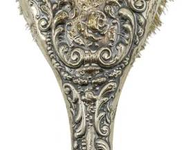 179 - Sterling Silver Hairbrush 6.5" (Description): Sterling silver hairbrush featuring an ornate  repousse handle with scrollwork design.  Measures 6.5 inches in length and weighs 4.21  ounces.