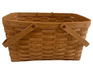 597 - Vintage Longaberger Basket 9"x16"x12" (Description): A handwoven basket featuring a rectangular  form with rounded edges. The basket is  constructed in a traditional splint weave  pattern with a natural honey-toned finish. It  features two sturdy swing handles that fold flat when not in use, attached with metal  rivets. The rim is reinforced with a wrapped  edge for durability. Measures 9"x16"x12".