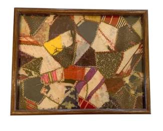 1170 - Patched Patch Quilt Art 15"x11.5" (Description): This textile artwork features a traditional  crazy quilt pattern with various fabric  patches joined together with decorative  stitching. The piece is presented in a wooden  frame.