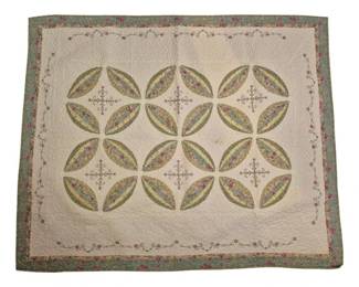 1304 - Cathedral Windows Quilt w/ Floral Border (Description): Featuring a cream-colored background with  appliqued floral fabric leaf shapes arranged  in a classic interlocking circular design.  The quilt includes delicate embroidered  floral vine borders and decorative cross-stitch motifs between the pattern  blocks. Finished with a green floral print  border and coordinating pink floral outer  binding. Machine made 60 x 49
