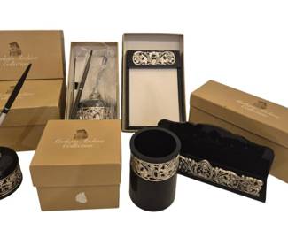 2727 - 5pc Gorham Archive Collection Desk Set (Description): Five-piece Gorham Archive Collection desk  accessories set featuring black lacquer  pieces accented with ornate silver-toned  decorative trim in a floral scroll pattern.  The set includes a pen holder with stand, pencil cup, note pad holder, and additional  coordinating pieces. Items come with their  original Gorham Archive Collection boxes.