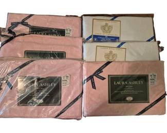 3764 - Laura Ashley & Cannon Twin Sheets Lot (Description): A collection of six twin sheets including  five fitted sheets and one flat sheet. The  lot features Laura Ashley pink sheets in  their original packaging with 200 thread  count, along with a Cannon Royal Family Court de Versailles sheet in ivory/cream. All  sheets remain sealed in their original retail  packaging.