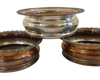 389 - 3 Wooden Bottomed Bottle Coasters 6"x2" (Description): Three silver-plated bottle coasters featuring  wooden bottoms. Each coaster measures 6  inches in diameter and 2 inches in height.
