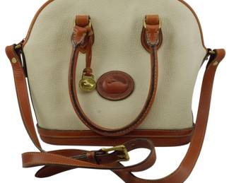 1784 - Dooney & Bourke Cream AWL Domed Zip Satchel (Description): Dooney & Bourke cream All Weather Leather  domed zip satchel featuring British tan  leather trim, dual top handles, and a  detachable adjustable crossbody strap. The  bag displays the signature duck logo medallion and brass hardware accents.  Measures 10inches x 12 inches x 4 inches.