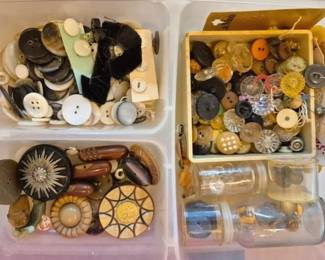 1454 - Plastic Box Full of Vtg Buttons 3"x10"x13" (Description): A plastic box filled with a large assortment  of vintage buttons in various materials,  sizes, and styles. The collection includes  mother of pearl, Bakelite, wood, bone, metal,  and plastic buttons ranging from decorative ornate pieces to practical sewing buttons.  Some buttons remain on original cards, and  the lot includes small glass jars with  additional buttons.