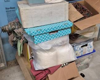 4116 - Several Boxes of Assorted Fabric (Description): Several boxes of assorted fabric including  various patterns, colors, and textures. The  collection includes chevron prints, floral  patterns, solid colors, and white linens.  Fabrics are housed in cardboard boxes and plastic storage containers.