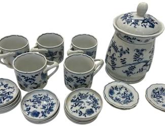 984 - Blue Danube Blue Onion Porcelain Group (Description): The set includes five mugs with twisted  handles, a covered canister or jar with a  finial lid, and assorted small plates and  butter pats in various sizes. All pieces  feature the traditional cobalt blue floral and botanical motifs on white porcelain with  scalloped edges trimmed in blue.