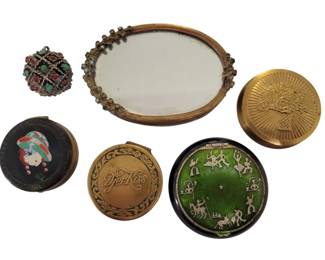 453 - Vintage Miniature Compacts & Mirror Lot (Description): A collection of miniature compacts and vanity  accessories. The lot includes a jeweled  sphere with red, green, and turquoise colored  stones, mirror with ornate brass frame  decorated with rhinestones, a gold-toned compact with embossed floral basket design, a  black enamel compact featuring a colorful  Art Deco lady portrait, a Djer Kiss compact  with gold-toned finish and scrollwork border,  and a striking green guilloche enamel