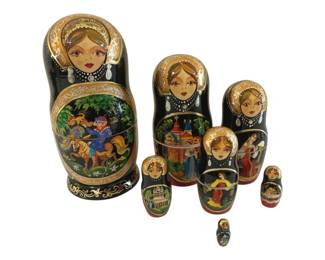 383 - Matryoshka Russian Nesting Dolls 9" (Description): Matryoshka Russian nesting dolls featuring  traditional hand-painted designs. The set  displays intricate gold scrollwork details  and a colorful scenic panel depicting figures  on horseback. Measures 9 inches tall.