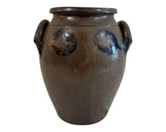 574 - Antique Salt Glazed Stoneware Crock 10"x7.5" (Description): Antique salt glazed stoneware crock featuring  applied lug handles on either side. The  vessel displays a classic ovoid form with a  rolled rim and cobalt blue decorative accents  near the shoulder. The characteristic salt glaze finish gives the piece its distinctive  textured, mottled appearance in earthy brown  tones. Measures 10 inches tall by 7.5 inches  in diameter.