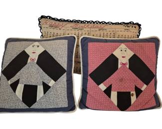 3787 - 3 Vtg Decorative Pillows w/ Amish Figures (Description): Three vintage decorative pillows measuring  10" x 10". Two feature quilted Amish-style  figure appliques, one on a blue floral  background with blue border and one on a pink  patterned background with gray border. The third pillow displays a calendar with "Happy  Birthday" text and decorative black scalloped  edge trim.