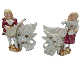674 - Pair Japanese Figural Ceramic Vase Planters (Description): Colonial-style figurines designed as vases or  planters, featuring a boy playing a mandolin  and a girl with a tambourine. Each planter  measures 9 inches by 8 inches by 4 inches.