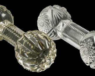143 - Two Glass Knife Rests (Description): Two glass knife rests featuring cut glass  designs in a dumbbell form with decorative  faceted ends connected by a central bar.