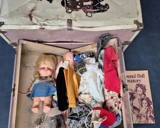 4152 - 2 Doll Trunks w/Doll & Clothes (Description): Two doll trunks containing an assortment of  doll clothes. The trunks include various  garments and accessories suitable for  dressing dolls.