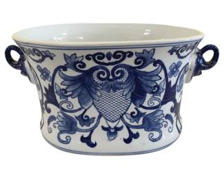 410 - Blue & White Porcelain Cachepot 6.5"x11" (Description): Blue and white porcelain cachepot or planter  tub featuring hand-painted decorative motifs  including scrolling foliate designs, floral  elements, and a central cartouche with  crosshatched pattern. The oval-shaped vessel is fitted with two ornate loop handles on  either side. Measures 6.5" x 11".
