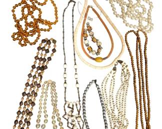 1970 - Assorted Beaded Necklaces Collection (Description): A collection of 11 assorted beaded necklaces  featuring various styles and materials. The  grouping includes amber-colored glass beads,  faux pearl strands, metallic beaded chains,  heishi-style disc beads, and decorative ceramic or painted beads. The necklaces vary  in length and design, offering a diverse  selection of costume jewelry pieces suitable  for various occasions.