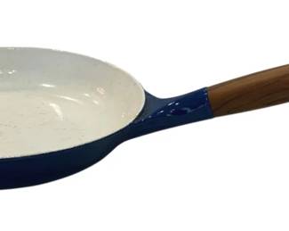 910 - Michael Lax for Copco Enamel Cast Iron Skillet (Description): Blue enamel cast iron skillet. Features a  wooden handle with metal end cap and a small  side handle for easy lifting. The interior  appears to be light-colored enamel. Measures  20 inches by 10 inches by 2 inches. Shows some wear to the enamel consistent with age  and use.