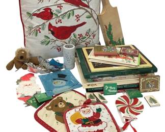 947 - Christmas Holiday Decor & Cookbook Lot (Description): Assorted Christmas holiday lot featuring a  cardinal bird embroidered throw pillow with  red piping, decorative wooden cutting board  with holly design, Christmas-themed cookbooks  including Southern Living editions and Old World Favorite Christmas Recipes, holiday pot  holders with Santa and teddy bear designs,  peppermint candy ornament, Santa die-cut  decoration, snowman napkins, small plush  reindeer, decorative candle, and various