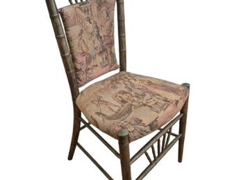 1287 - Vtg Faux Bamboo Chair w/ Tapestry Upholstery (Description): Vintage faux bamboo side chair featuring  tapestry upholstery on both the seat and  back. The chair displays a classic turned  bamboo-style wooden frame with spindle back  details topped by decorative ball finials. The tapestry fabric depicts figural courtly  scenes in muted tones of pink, cream, and  brown. Measures 34"x17"x16".