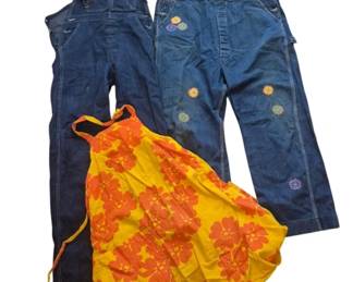 2793 - Vintage Denim Overalls & Floral Dress Lot (Description): A collection of vintage clothing featuring  two pairs of denim overalls and one dress.  The lot includes a pair of dark blue denim  overalls and a lighter blue pair decorated  with embroidered flowers and text. Also included is a vibrant yellow and orange  floral print halter-style dress or apron with  a tie waist. All pieces appear to be from  the 1960s-1970s era.