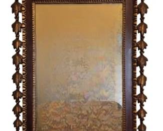 510 - Federal Style Mahogany & Gilt Eagle Mirror (Description): Federal style wall mirror featuring a carved  mahogany frame with gilt accents. The  pediment is crowned by a spread-winged eagle  finial perched atop a broken arch crest with  gilt bellflower swags. The rectangular mirror plate is surrounded by gilt beaded molding.  The sides are adorned with cascading gilt  acanthus leaf drops, and the base features a  scalloped apron with shell and gadrooned gilt  decoration. The mirror exhibits