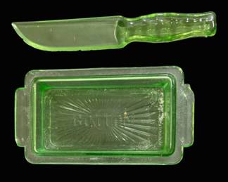 2771 - Green Uranium Glass Knife & Butter Dish (Description): Green uranium fruit & cake knife along with a  butter dish base. The pieces feature the  characteristic green coloration typical of  uranium glass, which fluoresces under  ultraviolet light. Roughness & chips on edges