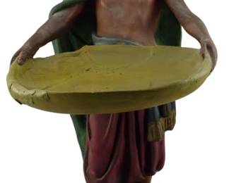 1888 - Ca. 1900 Blackamoor Chalkware Tray Bearer 17" (Description): A circa 1900 blackamoor chalkware figural  tray bearer. The figure stands holding an  oval tray, dressed in traditional attire with  a turban, draped cloak, and gathered  trousers, mounted on a circular base. Measures 17 inches in height.