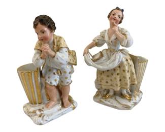 364 - 2 Ceramic Figural Vases 8.5" (Description): Pair of ceramic figural vases featuring a boy  and girl in 18th century attire with gold  gilt accents. Each figure stands beside a  fluted vase holder. Measures 8.5 inches in  height.