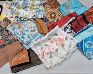 2853 - Lot of Assorted Colorful Fashion Silk Scarves (Description): A collection of assorted fashion scarves in a  variety of colors, patterns, and styles. The  lot includes striped, floral, paisley, and  geometric designs in hues of blue, red, pink,  brown, teal, and gold. One scarf features the Montana brand label. The scarves appear  to be made of silk or silk-like fabric,  suitable for accessorizing various outfits.